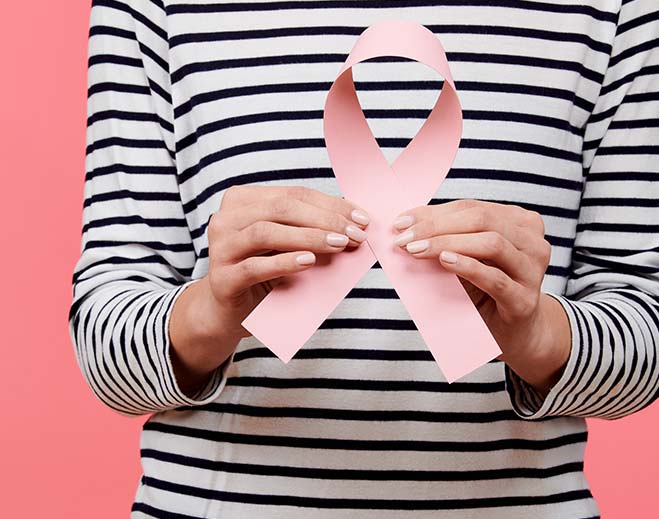 Person holding breast cancer awareness ribbon